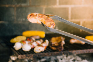 Persona utilizando su pinza para asados a la parrilla