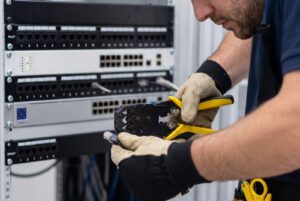 Técnico utilizando pinza ponchadora para contenedor telefónico